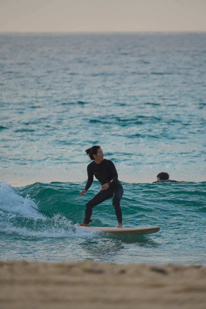 A surfer skillfully riding a wave in the ocean with another person in the background. Adventure awaits!