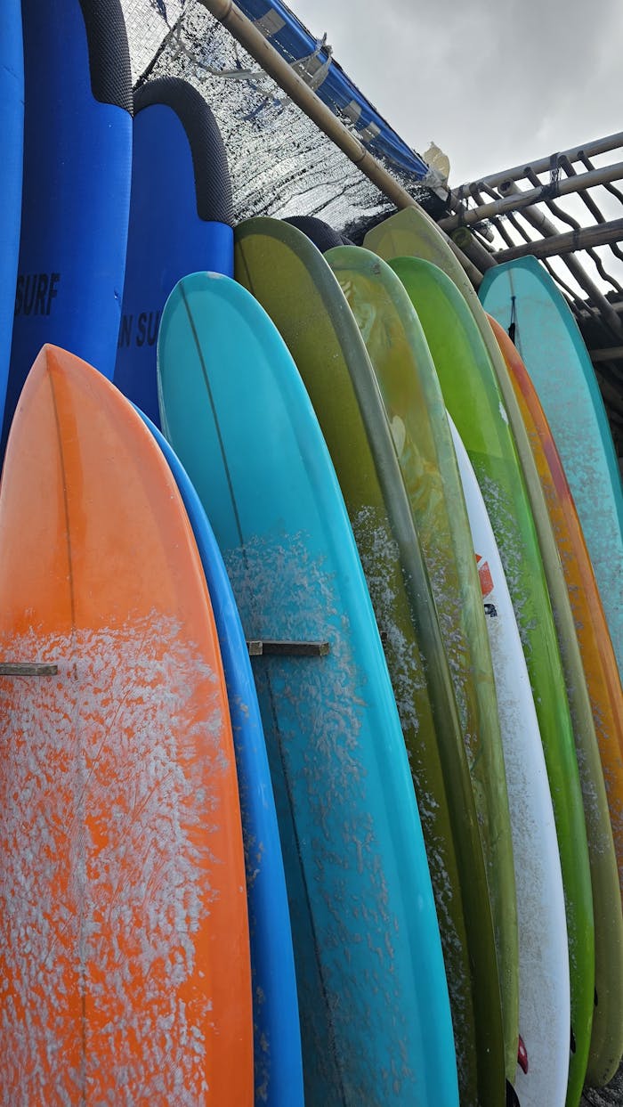 Vertical shot of vibrant surfboards lined up in Bali, Indonesia, reflecting a lively surf culture.